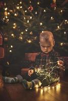 Little boy wearing checkered shirt at home during Christmas eve. photo