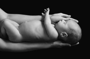 lindo bebé recién nacido en manos de la madre foto
