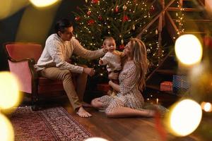 la joven familia feliz está celebrando navidad o año nuevo. foto