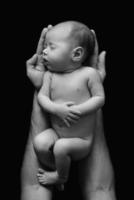 lindo bebé recién nacido en manos del padre foto