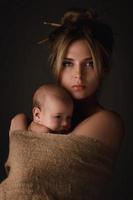 Beautiful mother and her little baby are wrapped in sackcloth photo