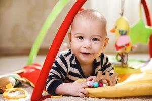 Cute baby is playing on the activity mat photo