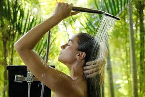 mujer lavándose bajo la ducha en un baño al aire libre foto