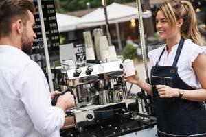 hermosa mujer barista vendiendo café al cliente foto