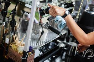 barista haciendo café usando una máquina de espresso profesional foto