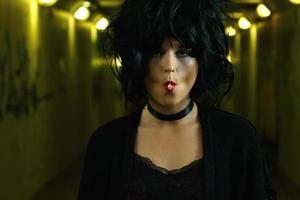 Freaky woman with black hair smoking a cigarette photo