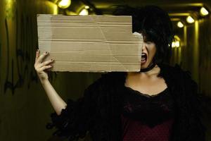 Strange and freaky woman with a piece of blank cardboard photo