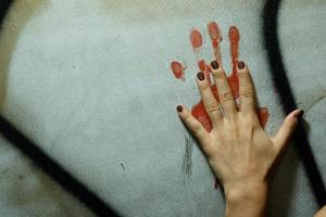 Female hand with bloody trace drawn on the wall photo