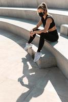 Athletic woman wearing face mask during summer street workout photo