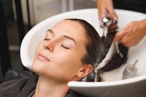 Woman in hairdresser salon during hair wash after haircut photo