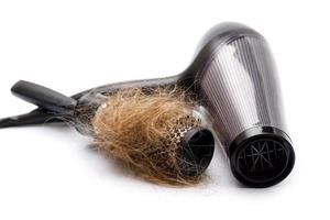 secador de pelo y cepillo con un trozo de pelo foto