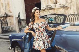 Woman wearing beautiful dress and retro convertible car photo