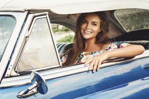 Beautiful woman driving a retro convertible car photo