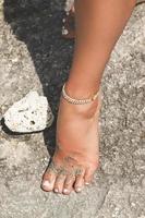 Closeup of Beautiful female foot and elegant anklet photo