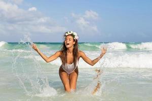 Happy woman playing and splashing in the sea photo