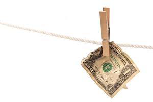 Crumpled US dollar banknote is hung on a rope with clothespin photo