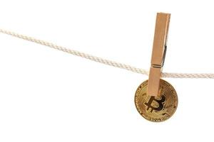 Bitcoin is hung on a rope with clothespins. photo