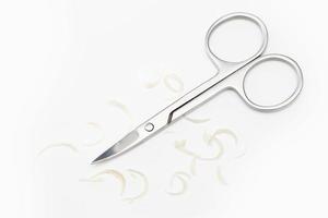 Manicure scissors and nail clipping on white background photo