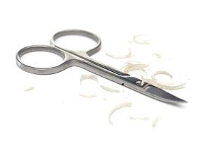 Manicure scissors and nail clipping on white background photo