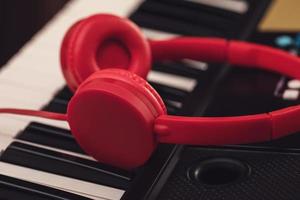 Closeup of red headphones over synthesizer keyboard photo