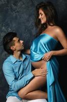 Sensual young couple wearing blue clothes waiting for a baby boy photo