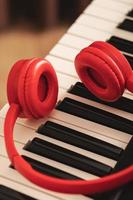Closeup of red headphones over synthesizer keyboard photo
