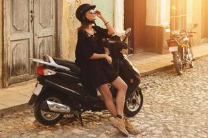 Woman driving scooter by the old city streets photo