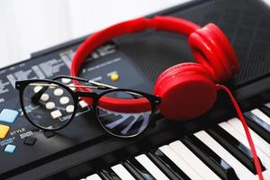 auriculares rojos y anteojos en el teclado del sintetizador foto