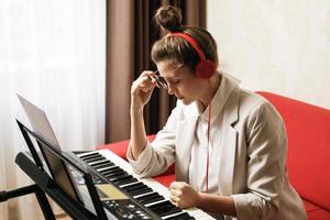 mujer compositora tiene agotamiento creativo durante una escritura musical foto