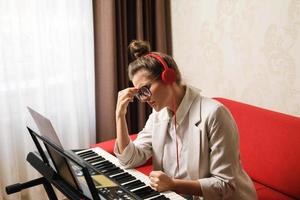 mujer compositora tiene agotamiento creativo durante una escritura musical foto