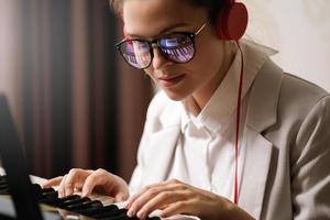 Young woman composer with a reflection of piano keys in a eyeglasses photo