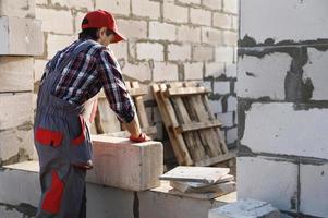 Bricklayer is working at the construction site photo