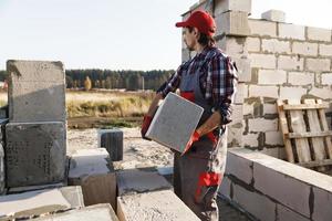 albañil está trabajando en el sitio de construcción foto