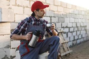 Bricklayer during the coffee break at the work photo