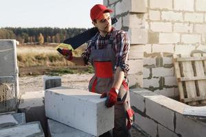 Bricklayer man is sawing autoclaved concrete blocks photo