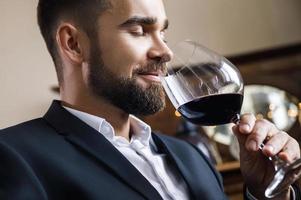 guapo hombre barbudo con una copa de vino tinto foto
