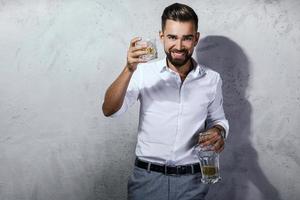 guapo hombre barbudo con un vaso de whisky foto