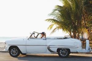 Happy young woman and retro convertible car photo