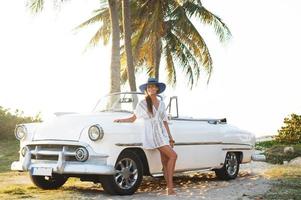 mujer joven feliz y coche descapotable retro foto