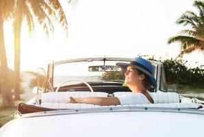 mujer joven feliz y coche descapotable retro foto