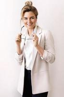 Young and happy businesswoman on gray background photo