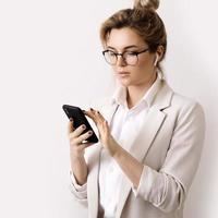 Young businesswoman talking by phone using wireless earbuds photo