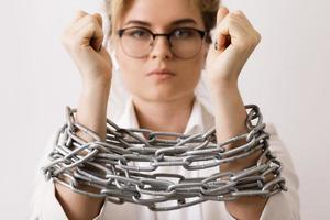 Sad business woman tied up with a chains photo