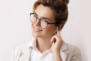 Businesswoman with wireless earbuds in the ears photo