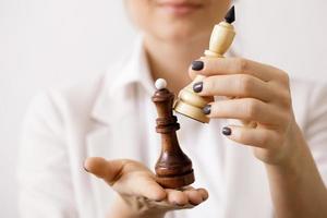 Smart businesswoman holding chess figure in her hands photo