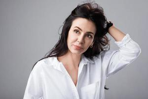 hermosa mujer de mediana edad con camisa blanca en estudio fotográfico foto