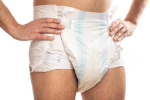 Woman wearing adult diaper against white background photo