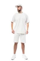 hombre vestido con gorra blanca en blanco, camiseta y pantalones cortos sobre fondo blanco foto