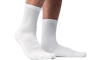 Male feet with white cotton socks on white background photo