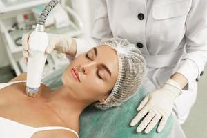 Doctor and woman client during radiofrequency lifting treatment in a medical aesthetic clinic photo